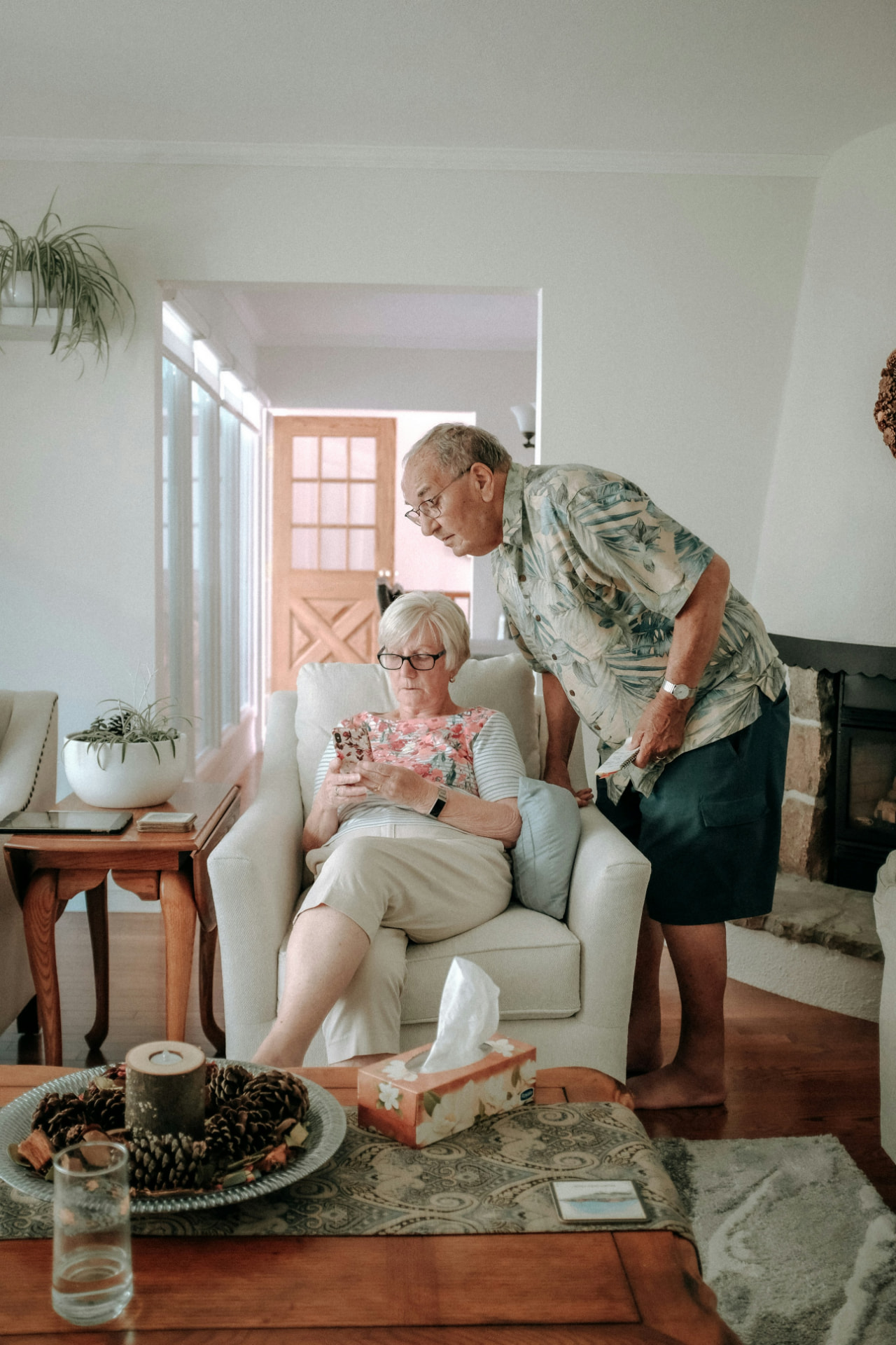 Older couple looking at a phone together in a living room
